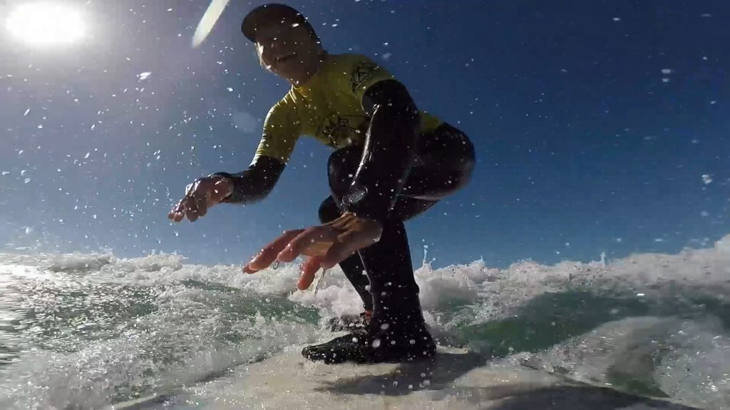 surfer girl smiling and riding on the wave
